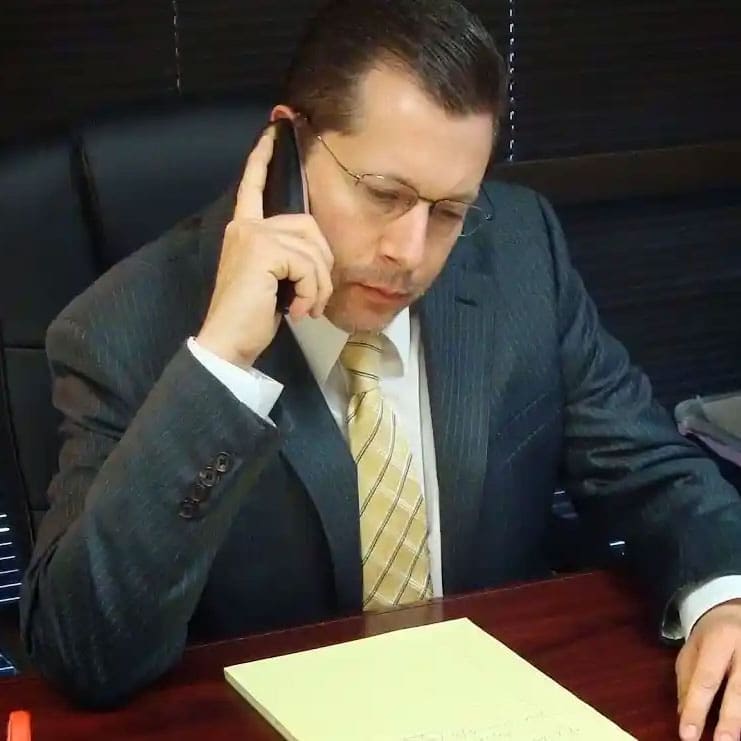 Attorney David L. McCarthy sitting at a desk talking on the phone